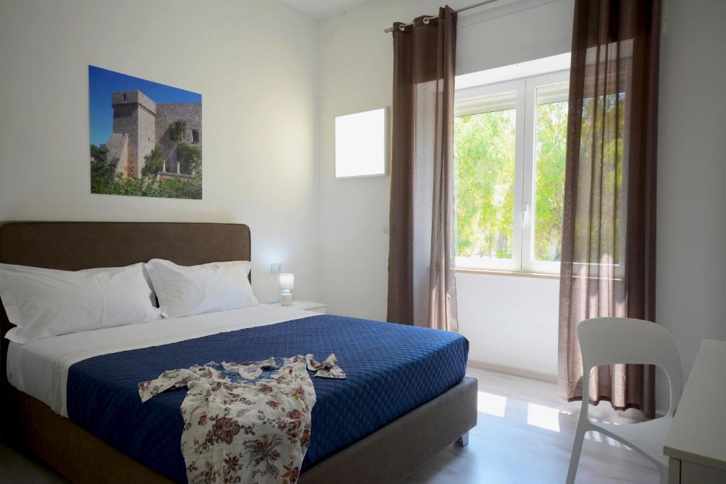 - une chambre avec un lit et une grande fenêtre dans l'établissement Camera & Caffè - Accoglienza Salentina, à Villaggio Resta
