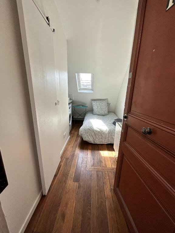 un couloir avec une chambre avec un lit et une porte dans l'établissement Amsterdam 11 - Saint-Lazare - Studio, à Paris