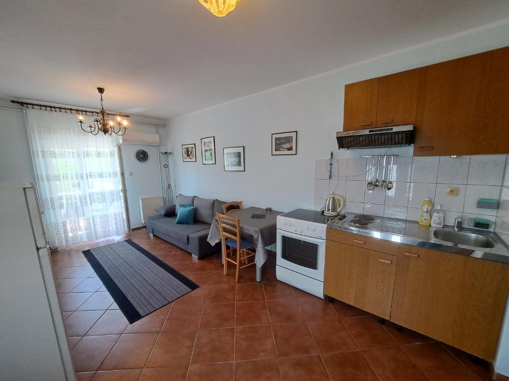 een keuken en woonkamer met een bank en een tafel bij Apartment Leo in Baška