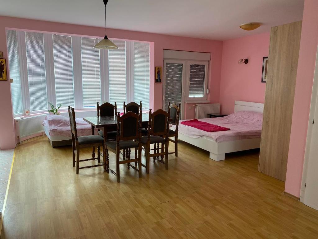 a dining room with a table and chairs and a bed at Guest House Trajkovic in Jagodina