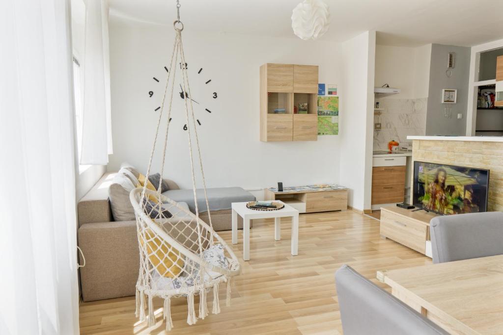 a living room with a swing chair and a couch at Apartment Pemper - Self check in and check out in Otočac