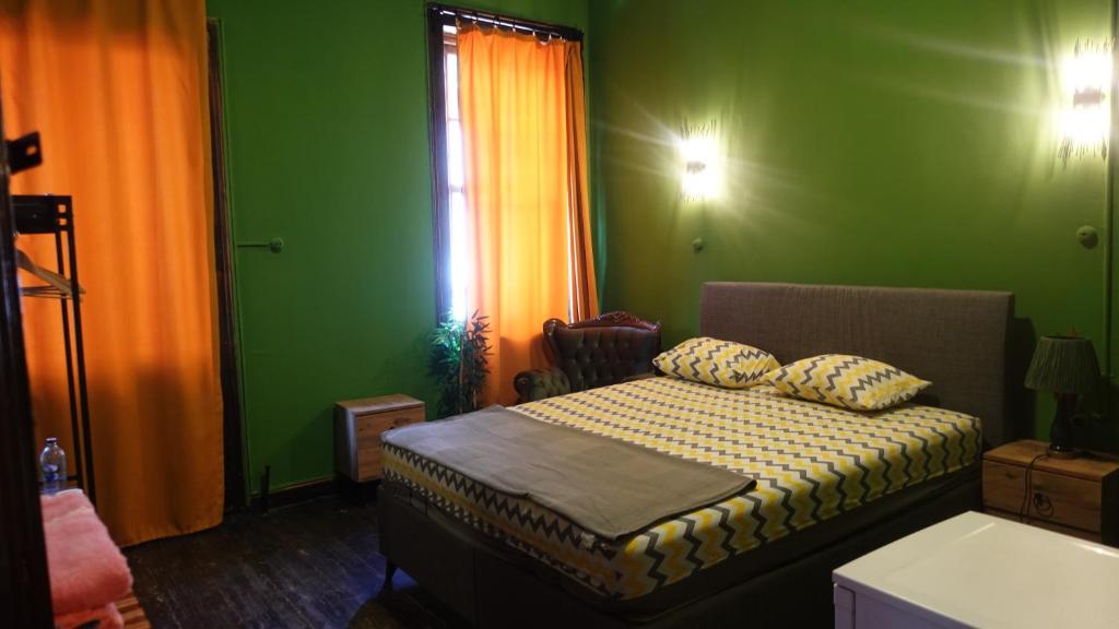 um quarto com uma cama numa sala verde em Titan House Hostel em Esmirna