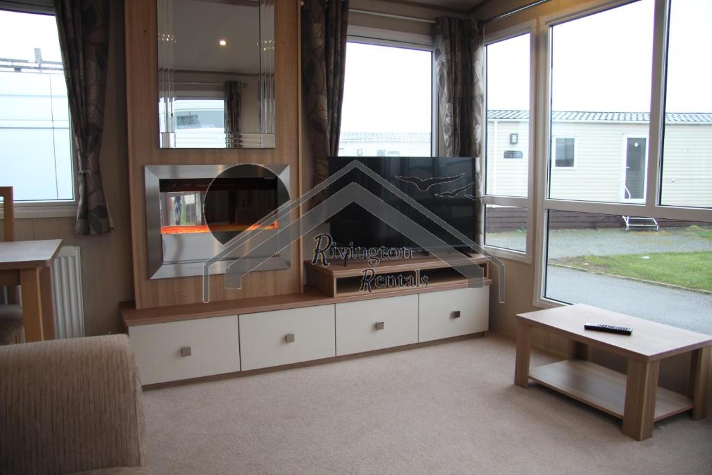 a living room with a tv and a large window at Tranquility - Static Caravan Lune Park on Parkdean Ocean Edge Resort in Heysham