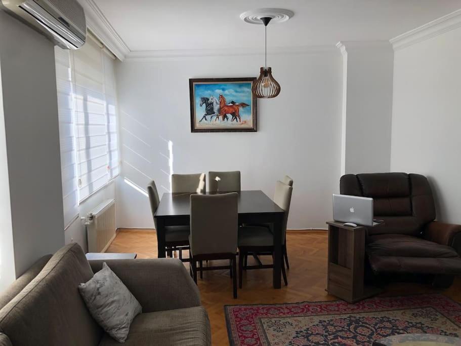 een woonkamer met een bank en een tafel met een laptop bij In the city center (800m from Cevahir shopping) in Istanbul