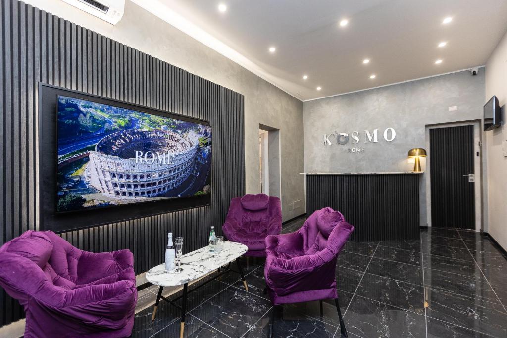a room with purple chairs and a tv on a wall at KOSMO ROME Luxury in Rome