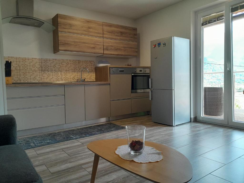een keuken met een tafel en een witte koelkast bij Apartma Maks & Anita in Bovec
