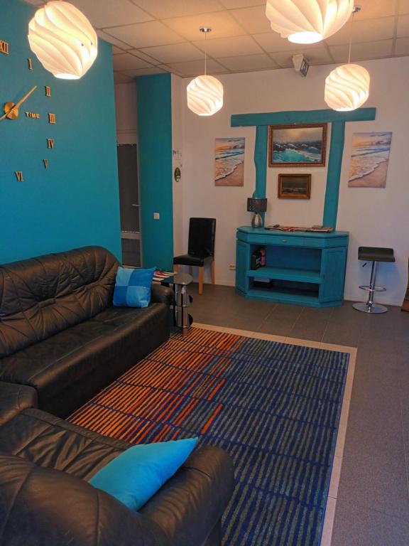 a living room with a couch and a blue wall at Jūras Vilks in Ventspils