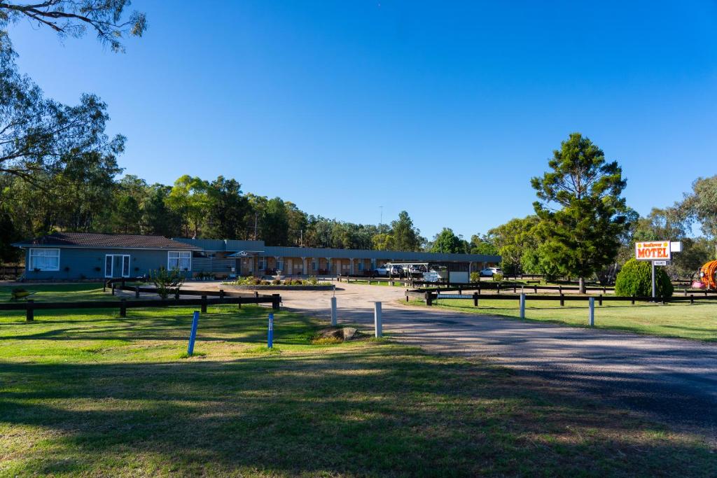 un grupo de mesas de picnic frente a un edificio en Sunflower Motel en Warialda