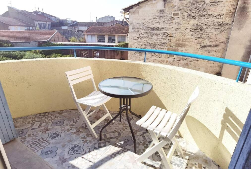 2 Stühle und ein Tisch auf dem Balkon in der Unterkunft Spacious 3-bedroom apartment with terrace and AC in the city centre in Avignon