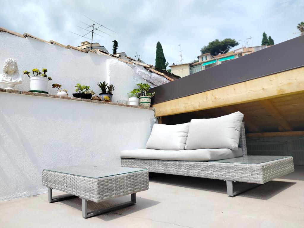 un sofá y una mesa de centro en el balcón en Attico romantico con terrazza Sanremo - Palm Street, 104, en San Remo