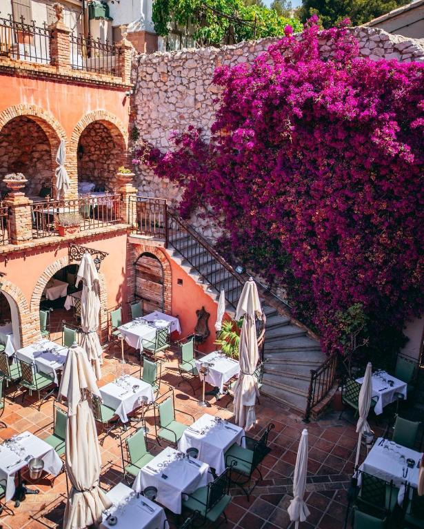 an outdoor restaurant with tables and purple flowers at Cabanon du Pêcheur, Parc National des Calanques in Marseille