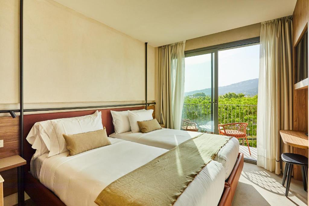 1 dormitorio con 1 cama grande y balcón en Silken Platja d'Aro, en Platja d'Aro