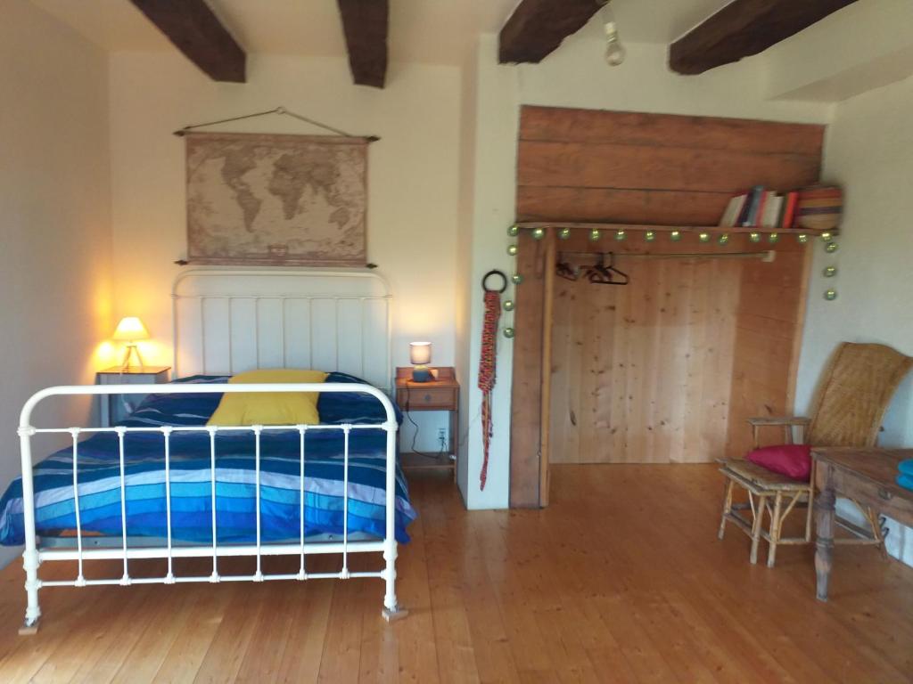 Schlafzimmer mit einem Bett und Holzboden in der Unterkunft Maison Lama 