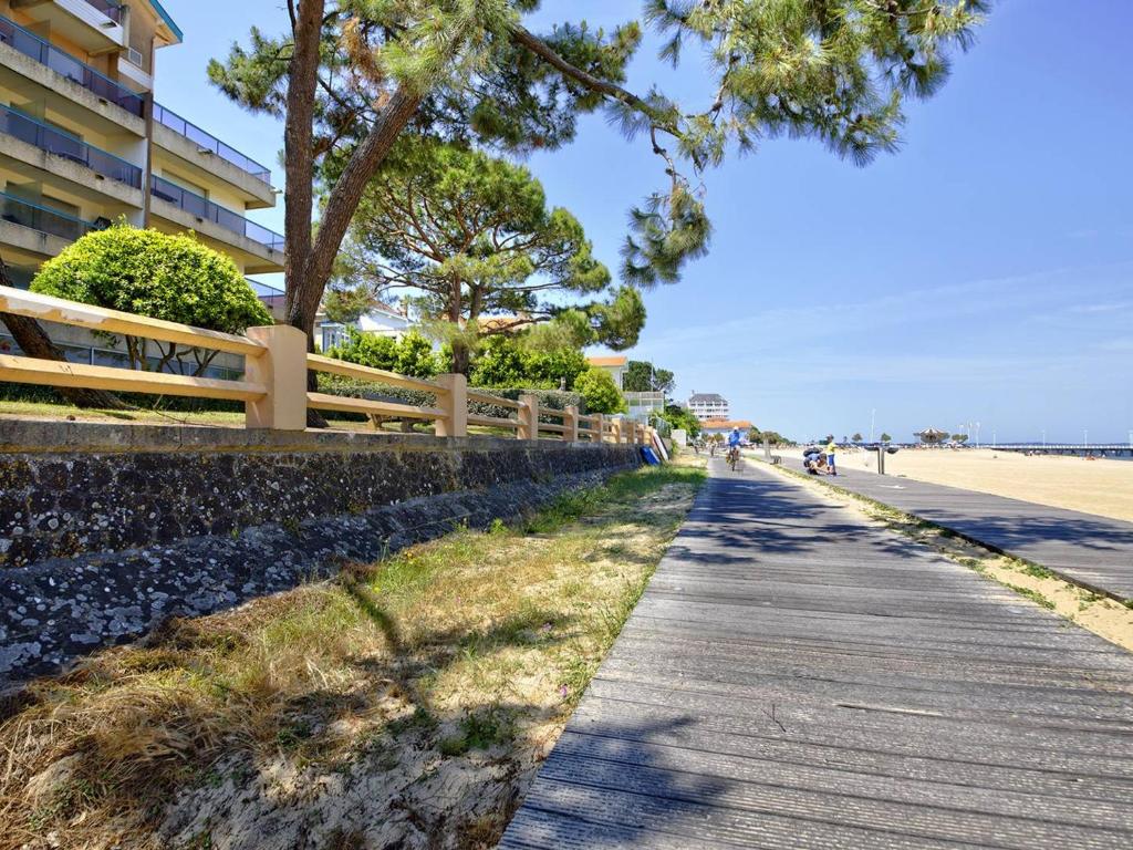 un trottoir à côté d'une plage arborée et d'un bâtiment dans l'établissement Arcachon: T2 Accès Privé Plage, Balcon, Parking - FR-1-433-19, à Arcachon