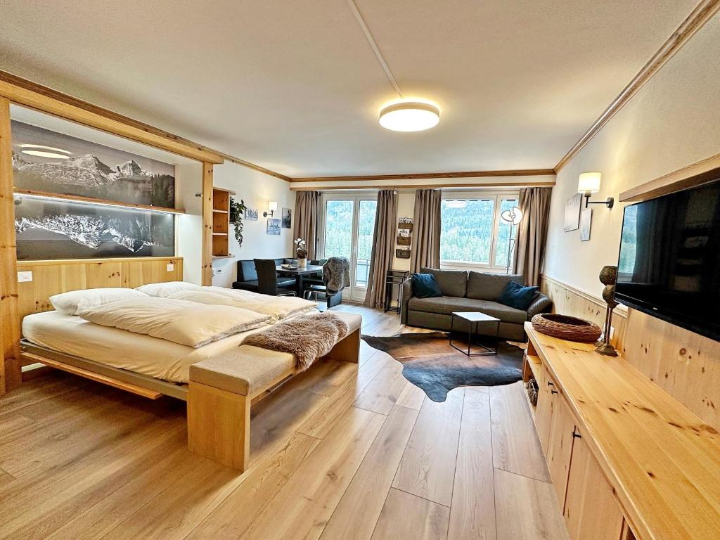 ein Schlafzimmer mit einem Bett und einem TV in einem Zimmer in der Unterkunft 45m2 Alpenschick mit Ausblick - Pool - 2P. - E405 in St. Moritz