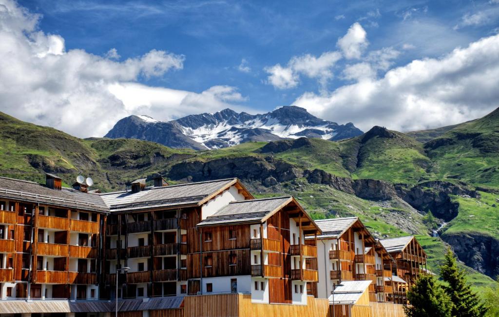 a row of buildings with mountains in the background at Vacancéole - Les Etoiles d'Orion in Orcières