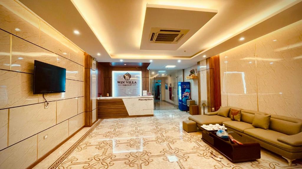 ein Wohnzimmer mit einem Sofa und einem TV in der Unterkunft Win Villa Hotel & Apartment in Hanoi