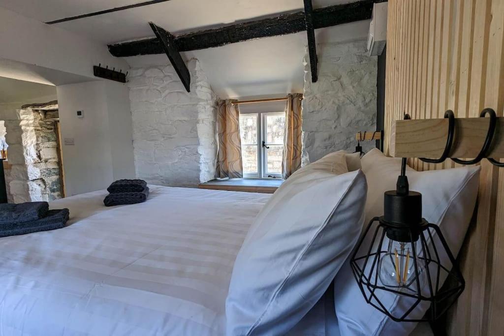 een slaapkamer met een groot wit bed en een raam bij Romantic Hideaway in Trawsfynydd