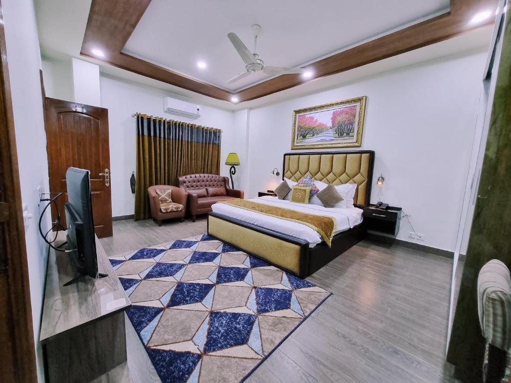拉合爾的住宿－Hayyat Luxury Suites，一间卧室配有一张床,并在一间客房内配有电视。