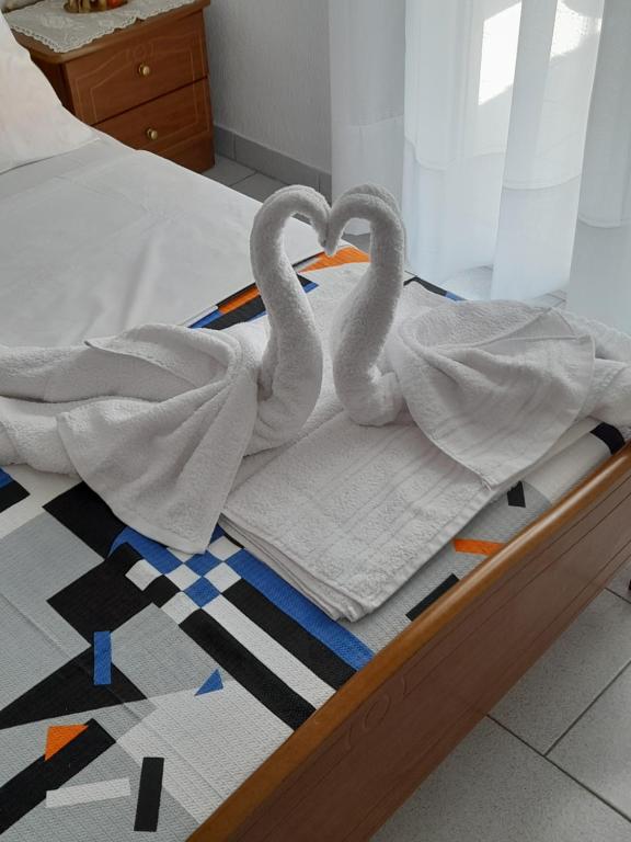 dos cisnes están sentados en una cama con toallas en Maisonette Basilissa, en Nea Potidaea