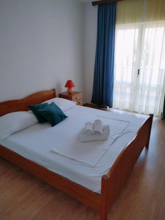 a bedroom with a large bed with two towels on it at Apartments Dalmacija in Podstrana