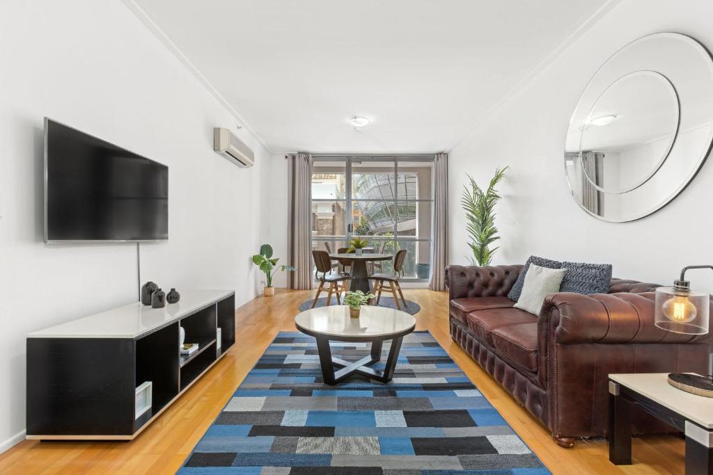 a living room with a couch and a table at A Comfy Studio for 5 Next to Darling Harbour in Sydney