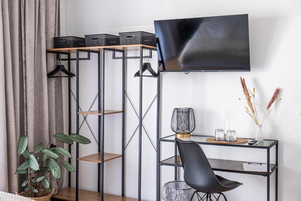 a room with a chair and a desk with a television at Hotel Fuchs & Hase SELF CHECK IN in Rosegg