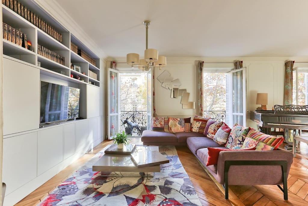 ein Wohnzimmer mit einem Sofa und einem Tisch in der Unterkunft Appartement 140m2 proche des Champs Elysées in Paris