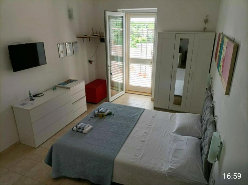 una camera con letto, lavandino e televisore di Casa Dolce Puglia Casa Vacanza a Castellana Grotte