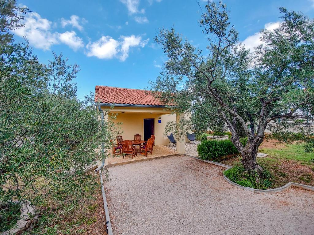 a house with a table and chairs and a tree at Kuća za odmor in Brzac