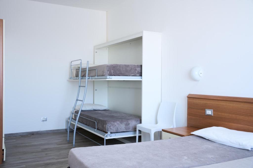 A bed or beds in a room at Appartamenti Residence Marcello-Piazza Torino-Lido di Jesolo