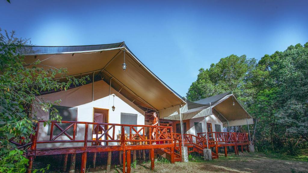 a building with a roof with trees in the background at Mara Leisure Camp in Talek