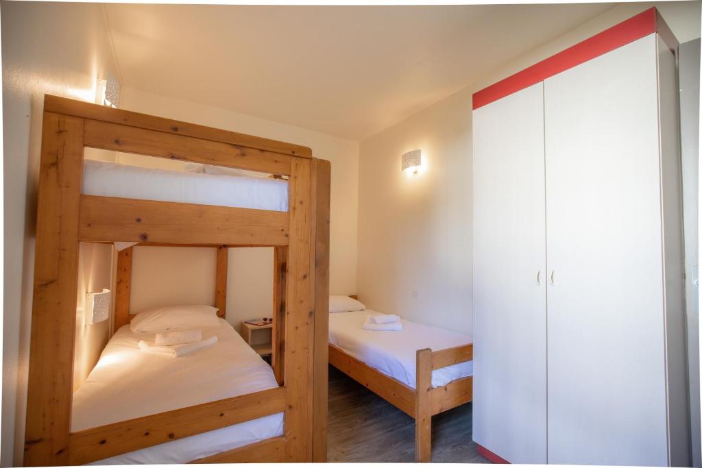 2 łóżka piętrowe w pokoju z szafą w obiekcie VVF Pays Basque Saint-Étienne-de-Baïgorry w mieście Saint-Étienne-de-Baïgorry