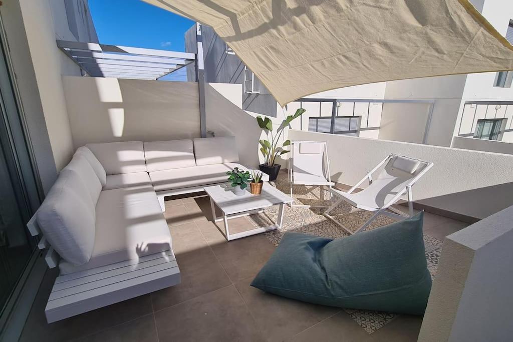 a living room with a couch and chairs on a balcony at White Medano apartment. New with fast Wifi in El Médano
