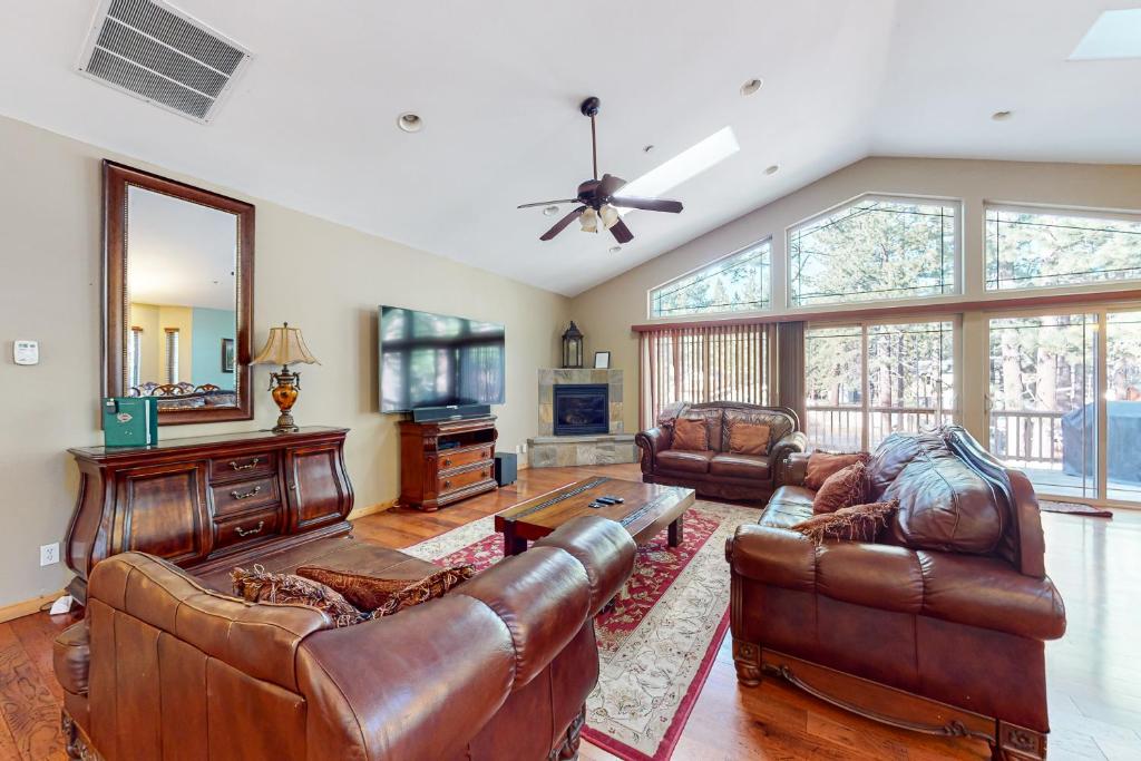 a living room with leather furniture and a ceiling fan at Heavenly Lake Hideaway in South Lake Tahoe