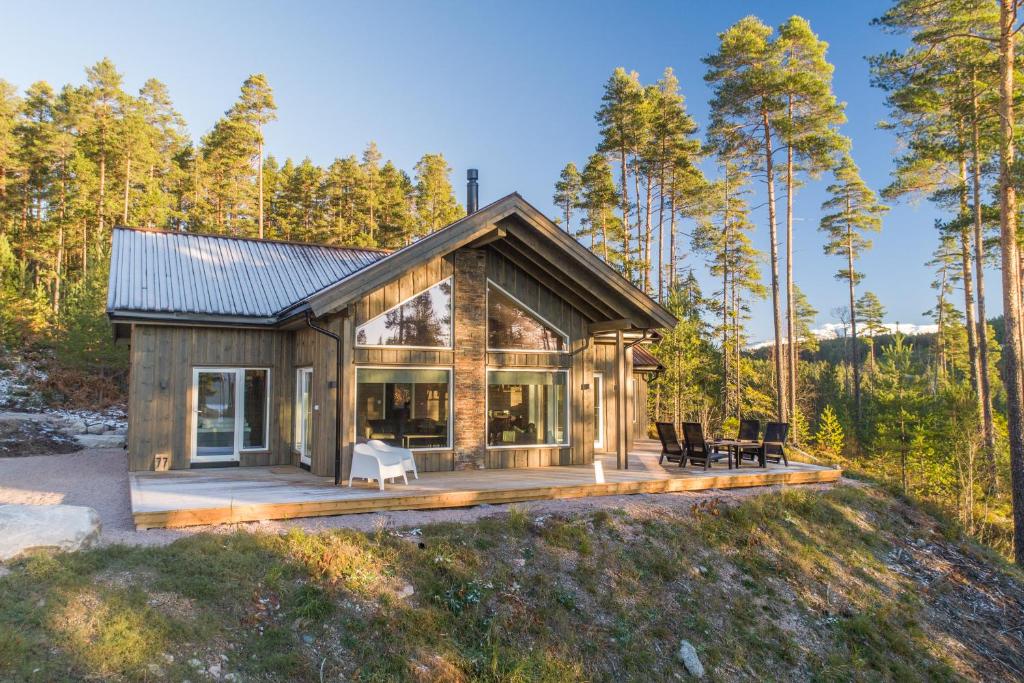 a house in the woods with a large deck at Vakantiehuis met geweldig uitzicht en hottub in Vradal