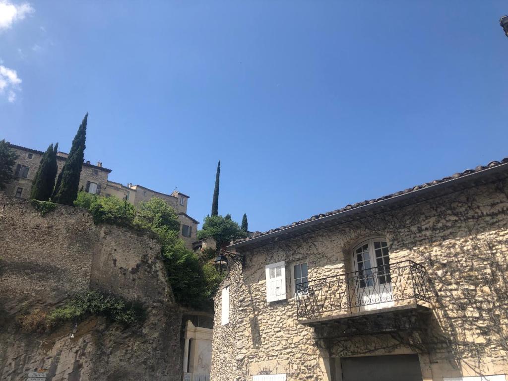 an old stone building with a balcony on a hill at Sur le Pont in Vaison-la-Romaine