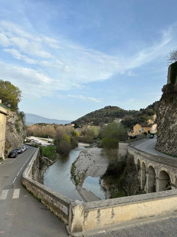 a bridge over a river next to a road at Sur le Pont in Vaison-la-Romaine