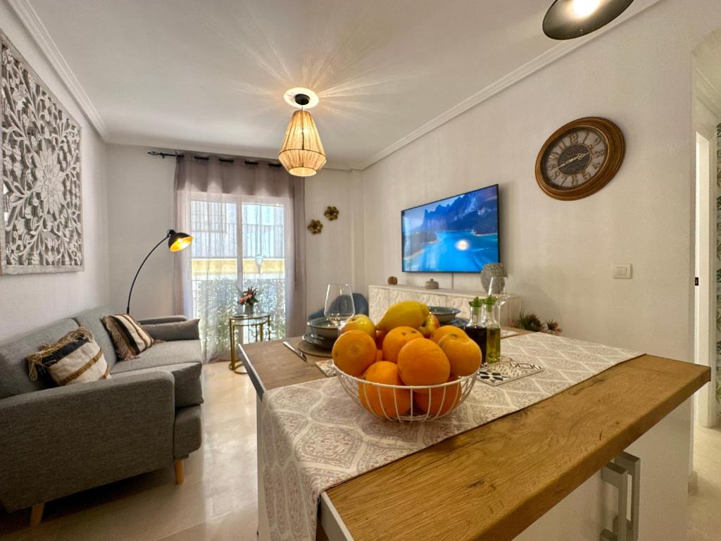 a living room with a bowl of oranges on a table at Casa Playa de Garrucha in Garrucha
