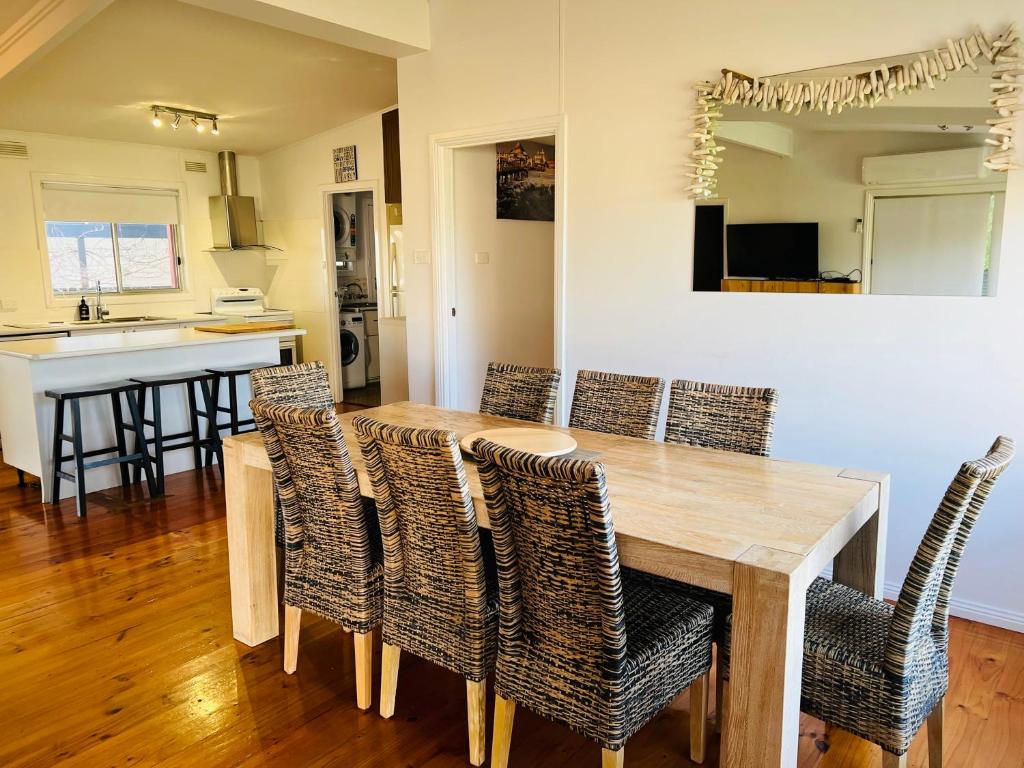 a dining room with a wooden table and chairs at Teddy's Shack - Pet Friendly in Robe