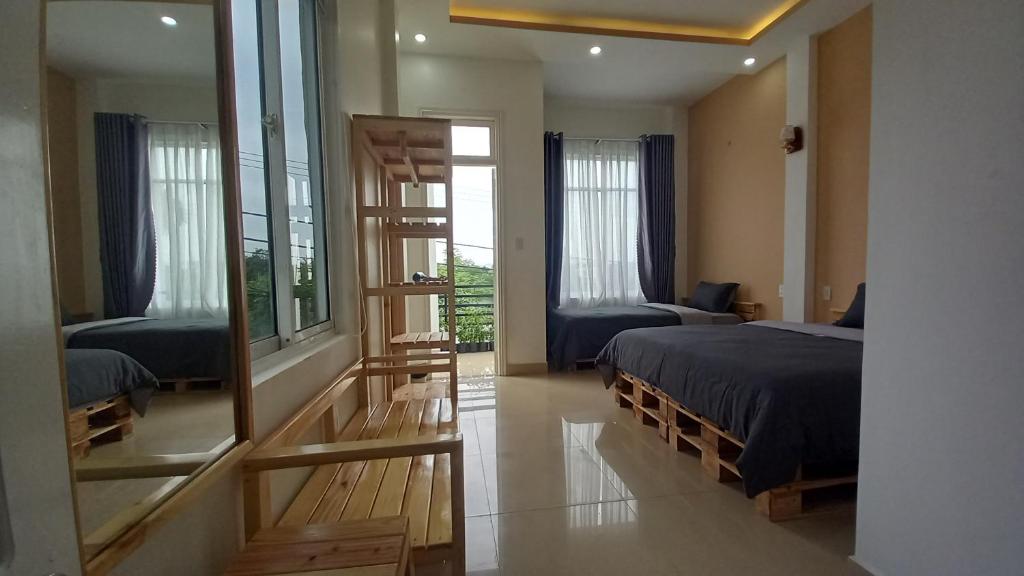 1 dormitorio con 2 camas y espejo en 2H Homestay, en Thôn Lại Thê