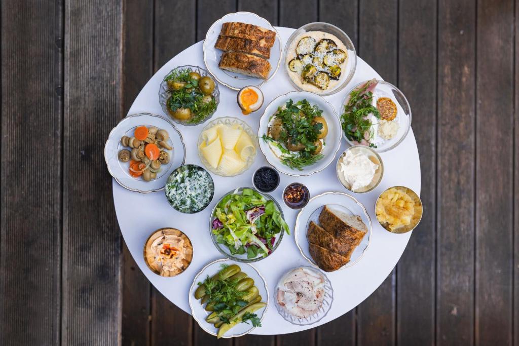Overhead view of round table filled with assorted small dishes, salads, pickles and bread.