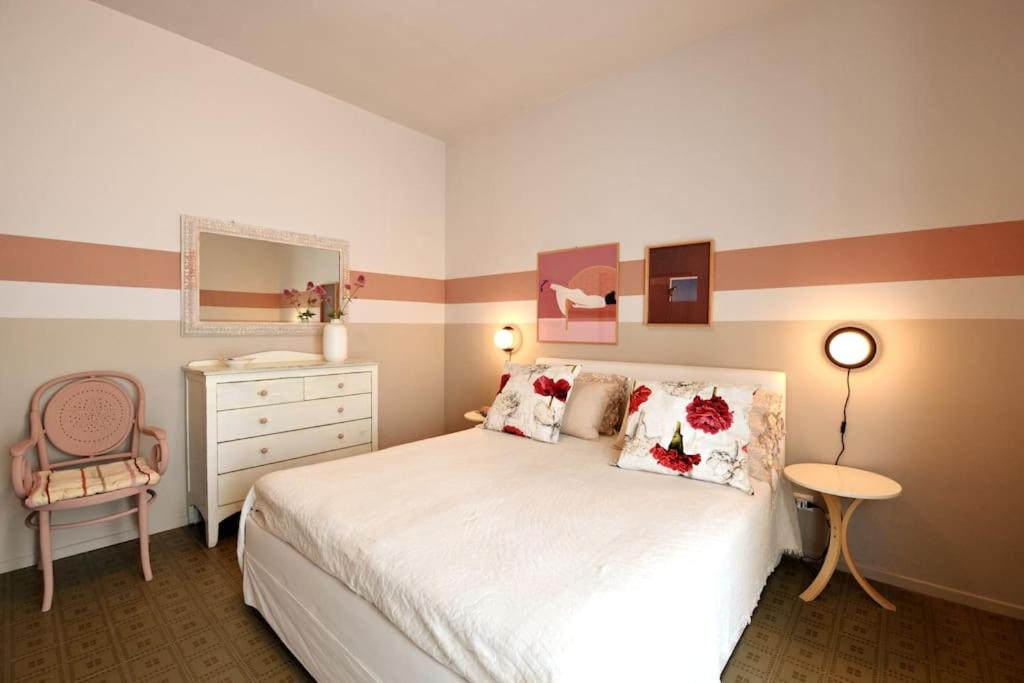 1 dormitorio con cama, tocador y espejo en Appartamento Doria [5 minuti a piedi dal mare], en Andora