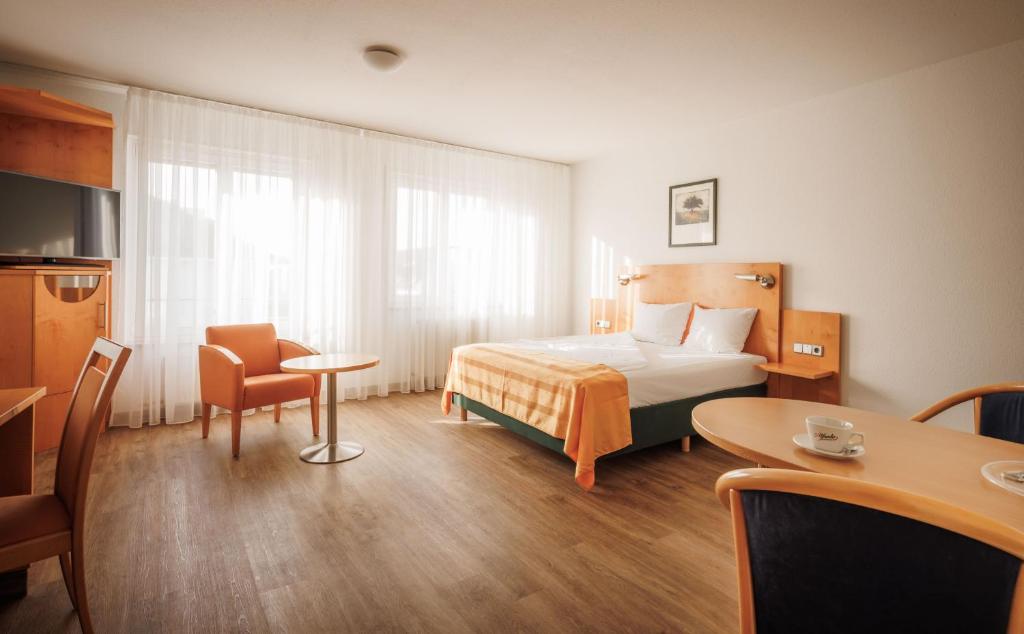 a hotel room with a bed and a table at Ariva Boardinghouse Platanenhof in Mannheim
