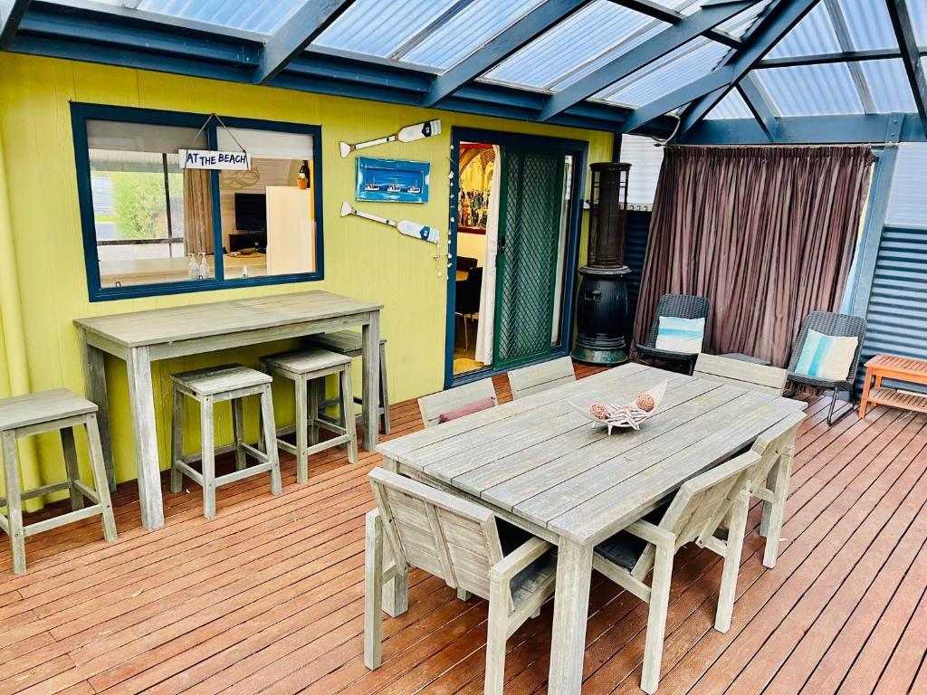 a deck with a wooden table and benches on it at Da Ja Surf - Pet Friendly in Robe
