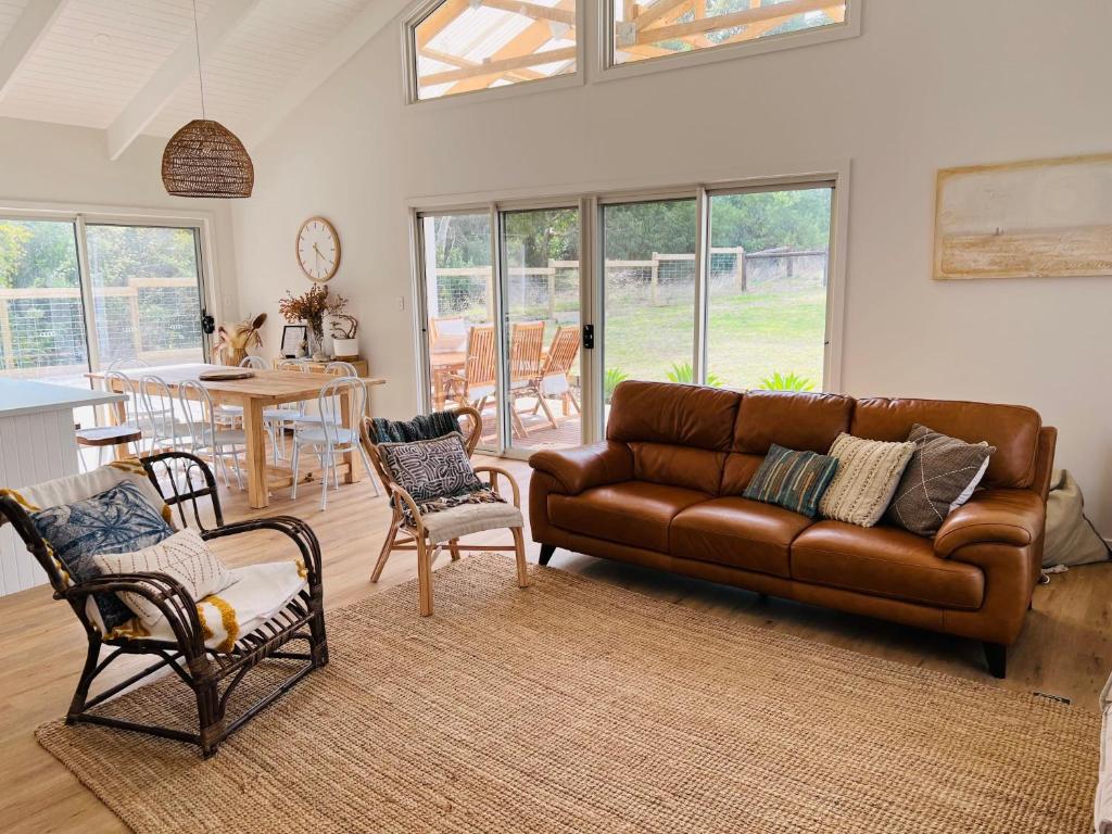 a living room with a brown leather couch and chairs at Bluebird Days - Pet Friendly in Robe