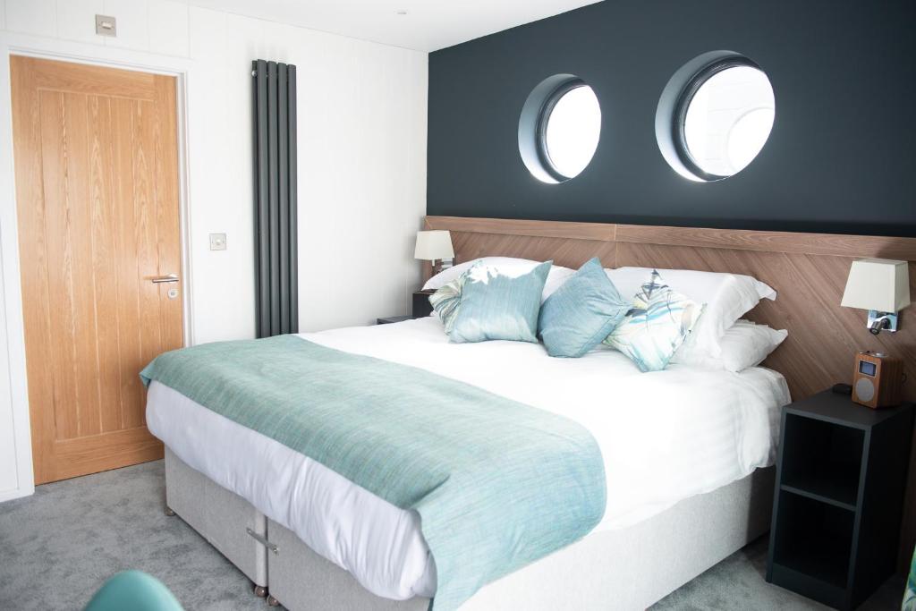 卡迪夫Rooms at Penarth Marina的卧室里有一张白色的大床，配有蓝色的枕头