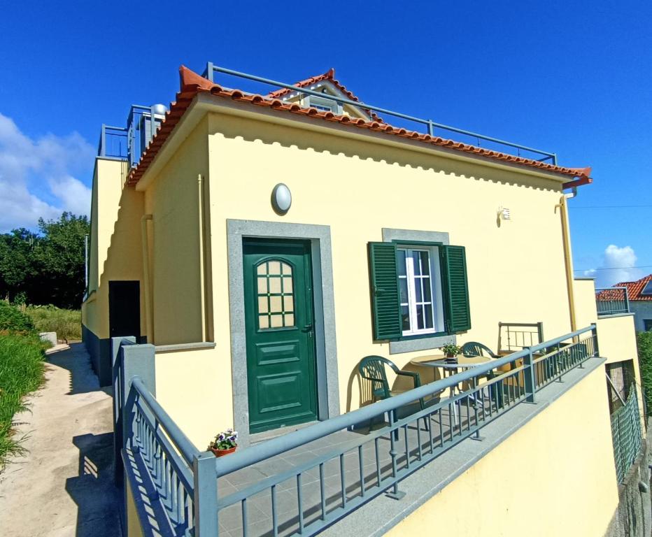 a house with a green door and a fence at A Toca in Santana