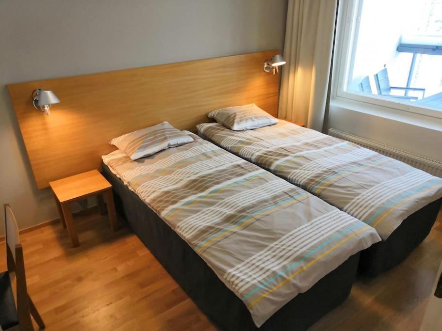 a bedroom with two beds and a window at Laatuhuoneisto Saimaa näkymällä- Luxury apartment by lake Saimaa in Imatra
