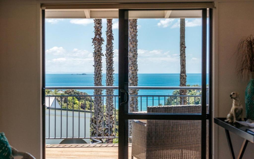 eine Tür, die auf einen Balkon mit Meerblick führt in der Unterkunft Cosy Palm Beach Cottage with Spectacular Seaviews in Palm Beach